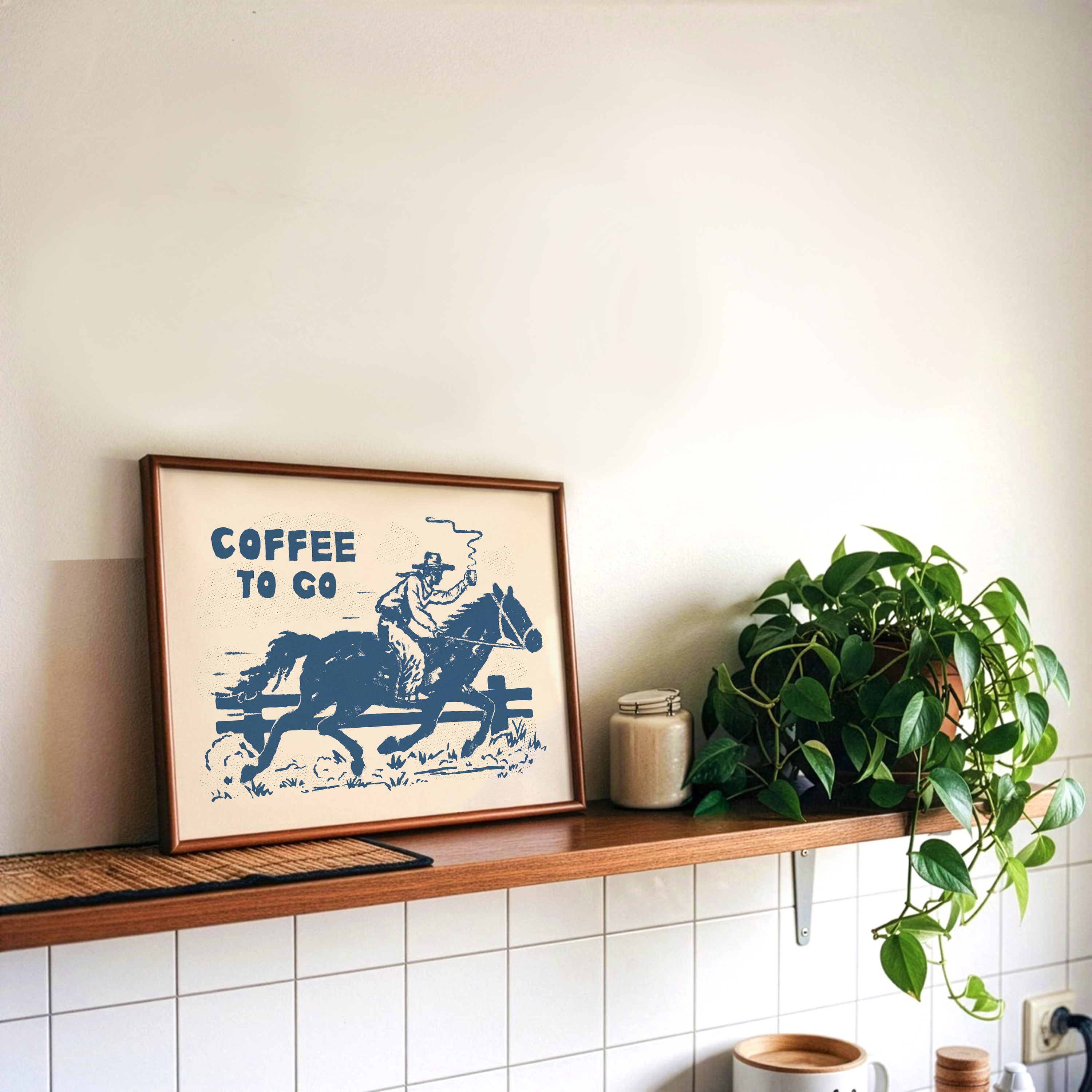 Framed poster of a person on horseback with 'Coffee to Go' text above a plant and shelf.