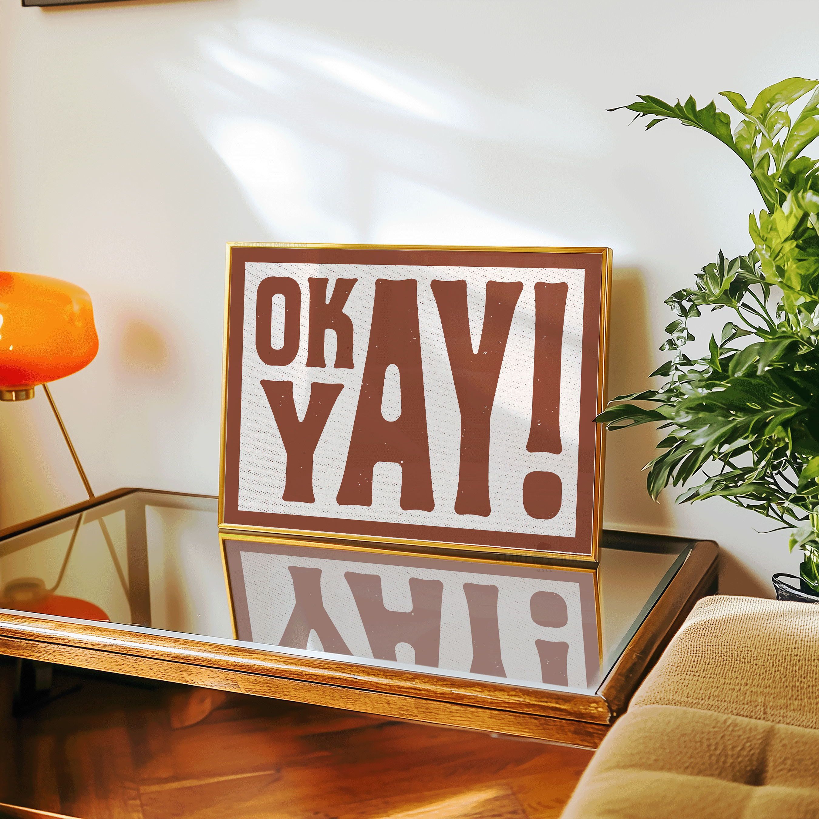 A close-up of a stylish bedroom vanity with the 'OK YAY!' print leaning against a mirror side table with funky lamp and lush indoor plants. The art adds a fun, sarcastic pop of color to a personal getting-ready space or a trendy girl’s room.